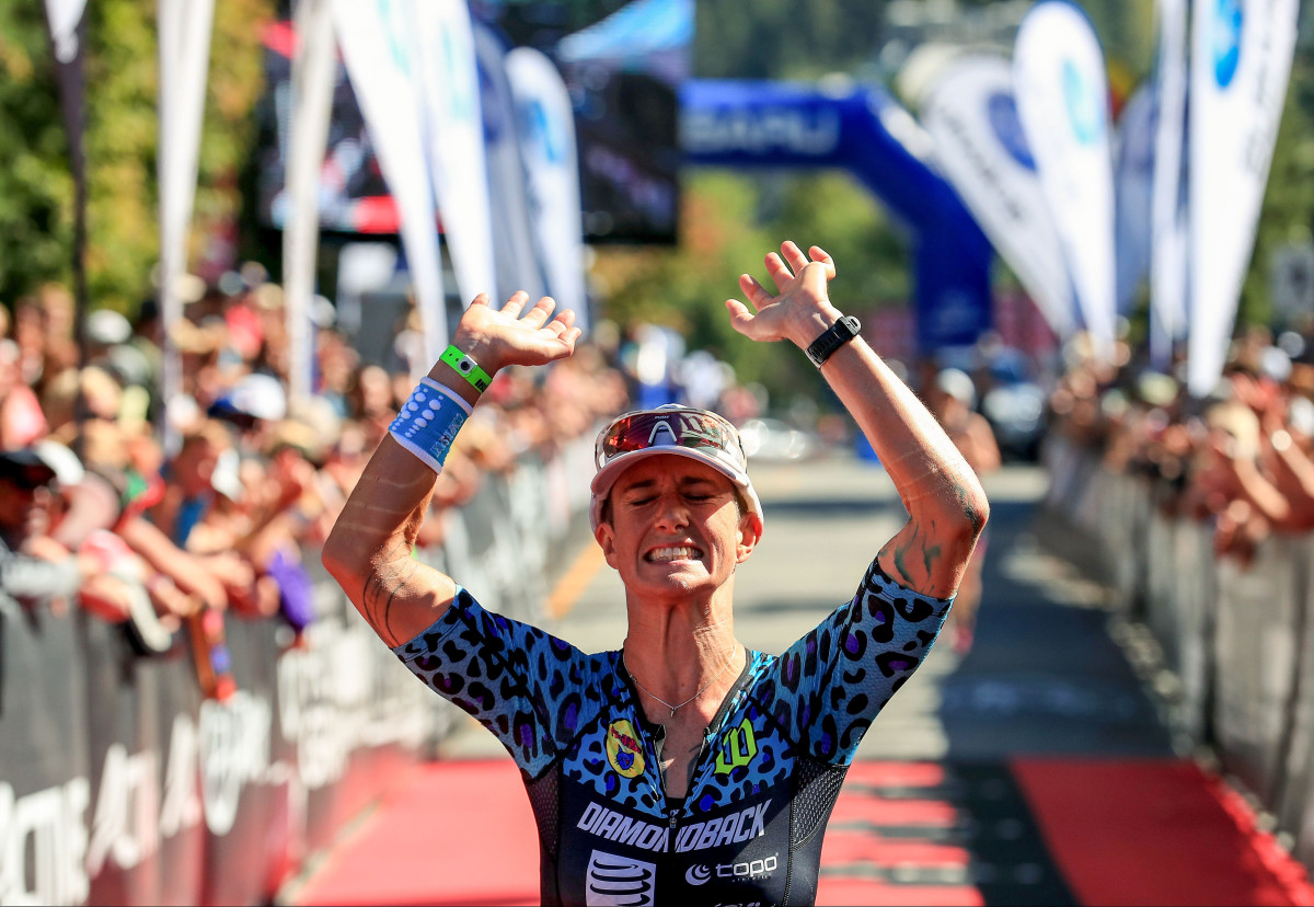 Rach McBride throws her hands up in celebration as she crosses a finish line